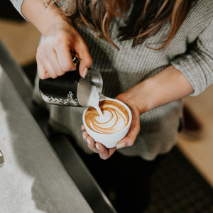 person pouring latte art