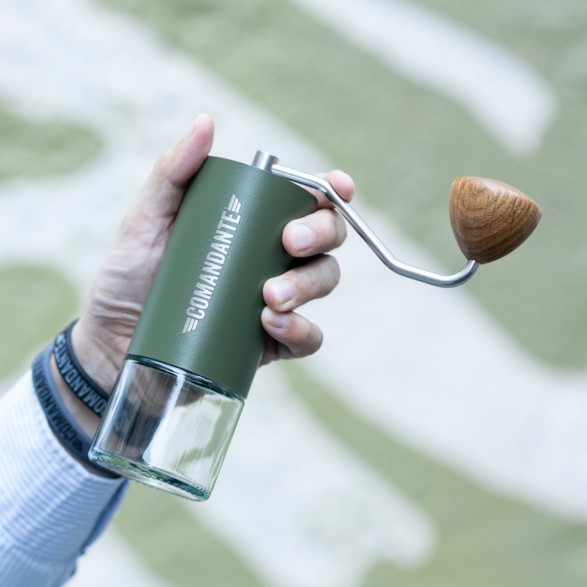 Man holding a Comandante grinder in green finish