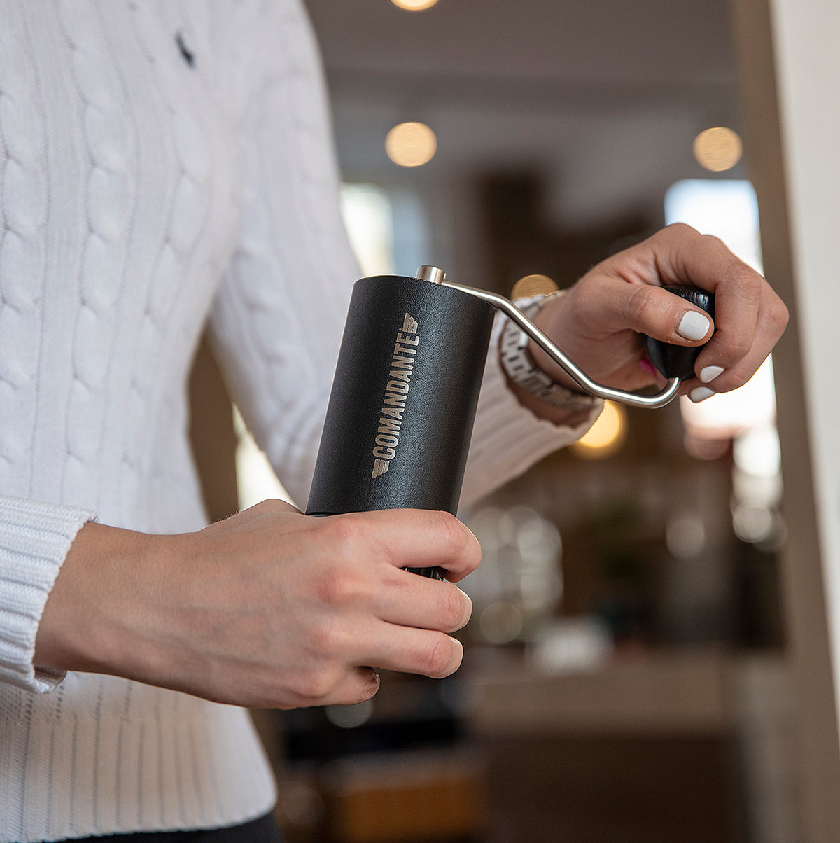 Man using a Comandante grinder in black finish