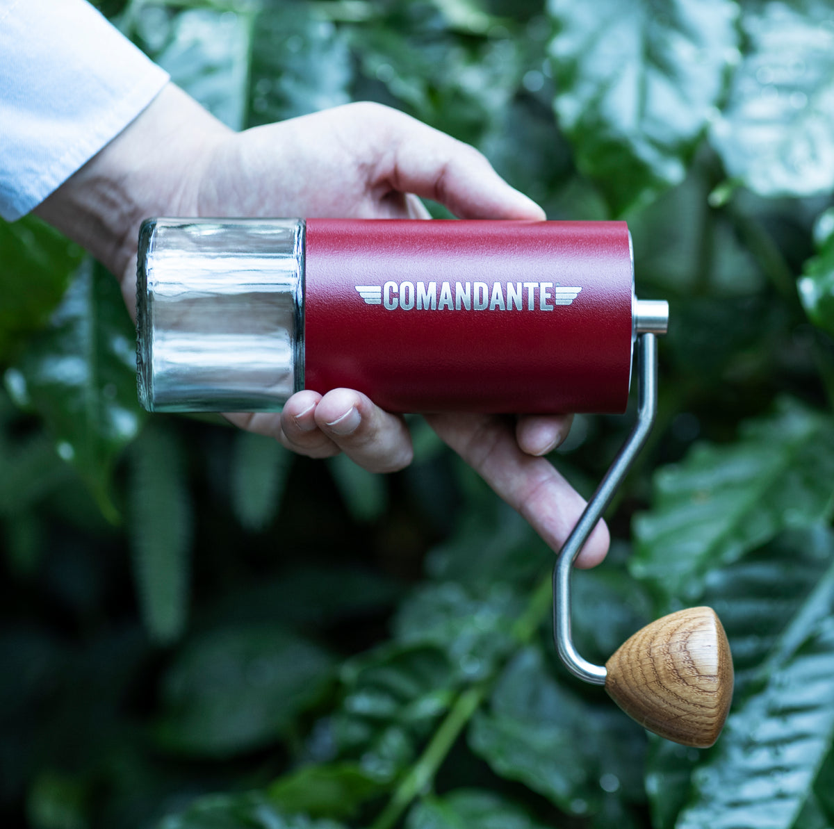 Man using a Comandante grinder in red finish