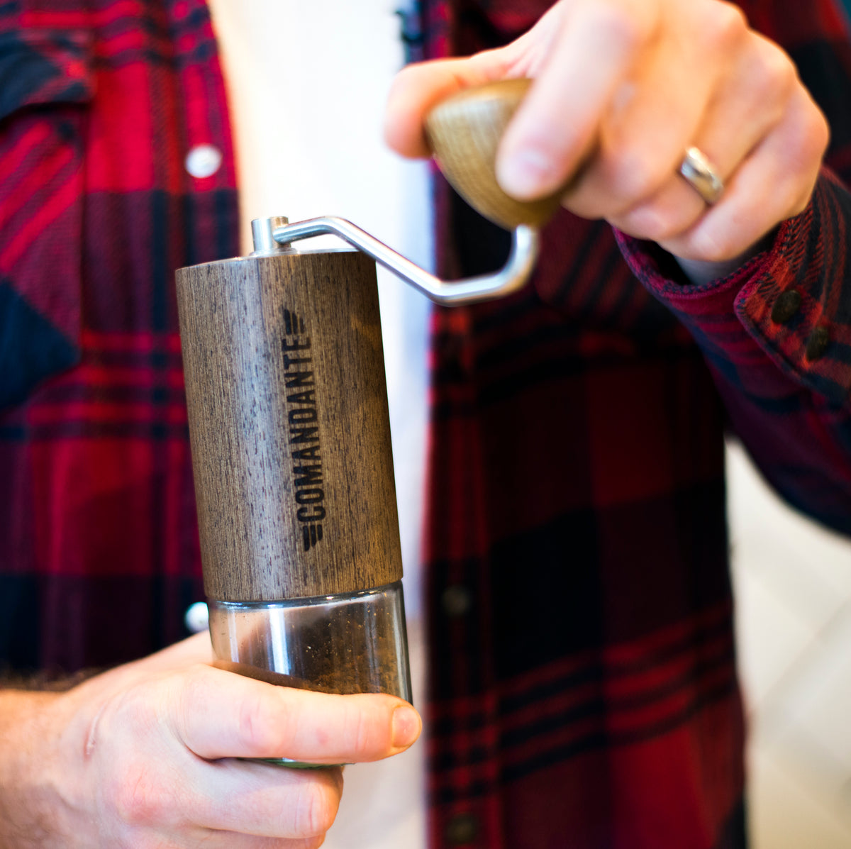 Man using a Comandante grinder in Wenge finish